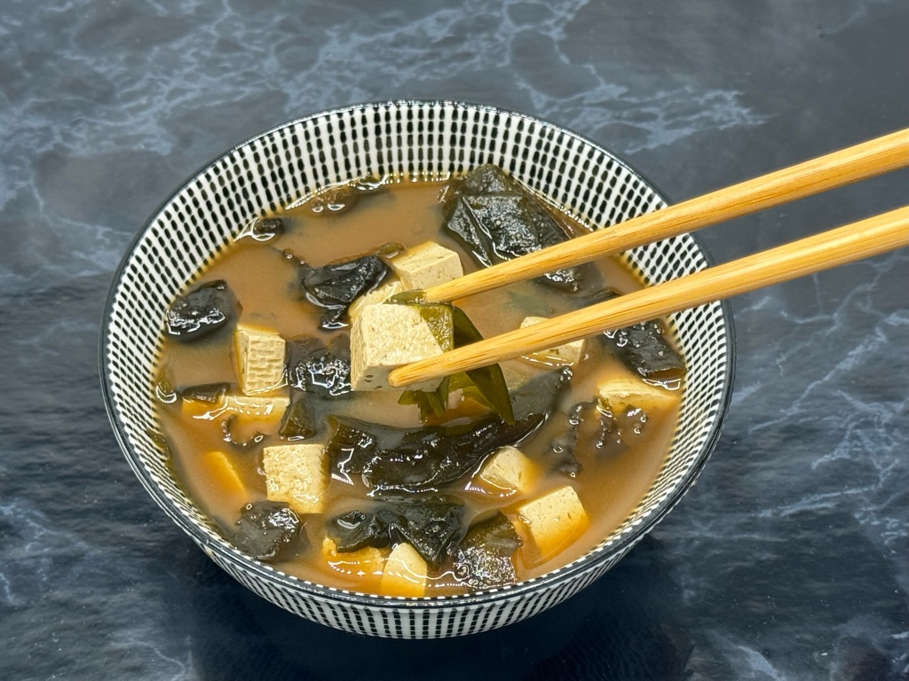 Recept na vynikajúcu japonskú miso polievku s tofu a wakame. Zaraďte ju do jedálnička po ukončení NFI protokolu. Ideálna polievka pri redukcii hmotnosti, pre diabetikov 2. typu i pre milovníkov japonskej kuchyne a zdravého životného štýlu. Polievka je nafotená v štýlovej bielo-čiernej miske s japonskými paličkami.